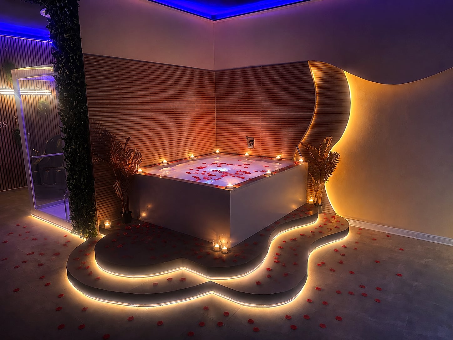 Whirlpool mit Rosenblättern und Kerzen im Romantik-Spa Friedrichshain