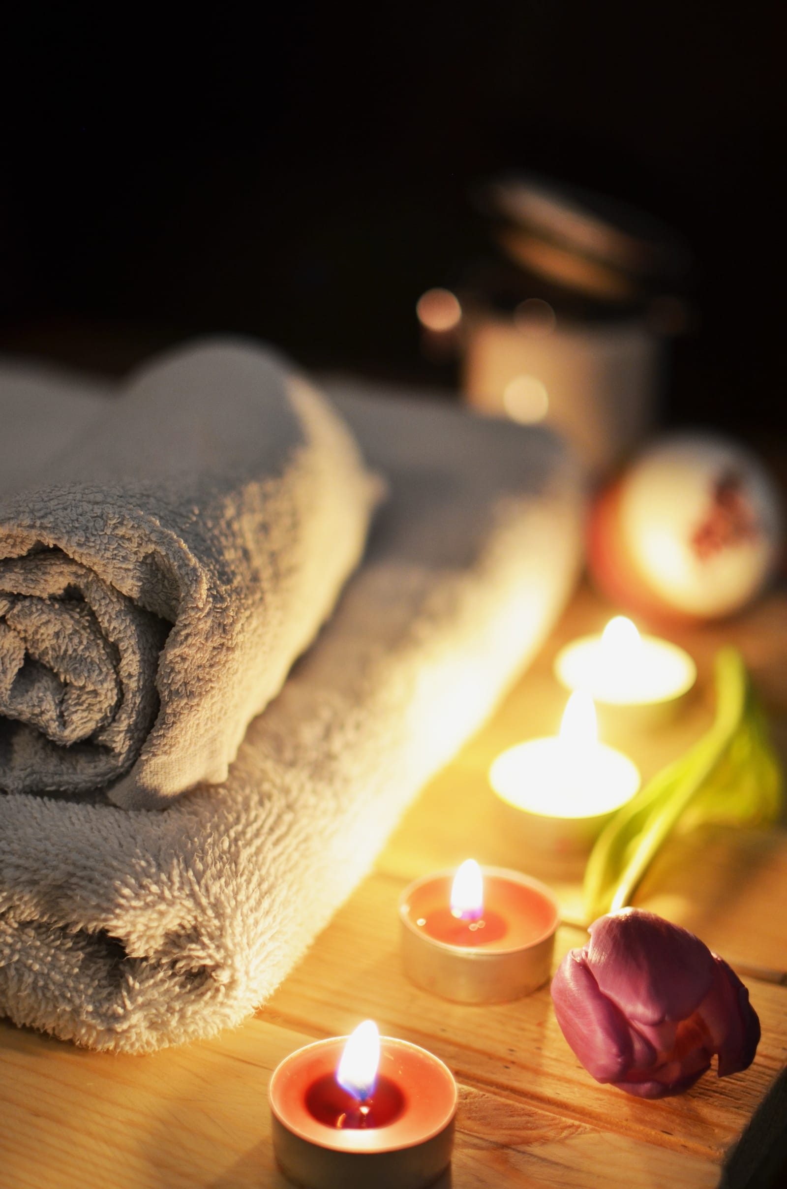 Aufgerollte Handtücher und brennende Kerzen — entspannte Spa-Atmosphäre